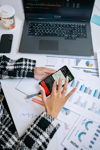 Laptop with a growth chart, calendar, and notebook representing business goal setting and growth planning.