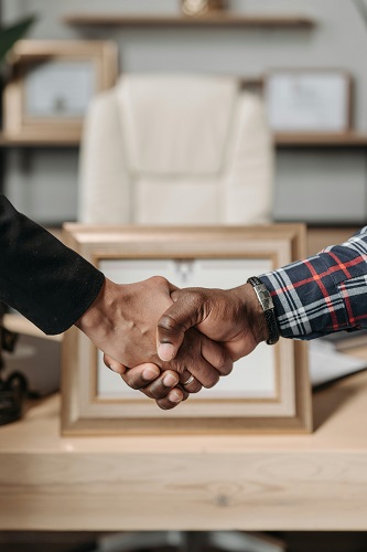 Two business professionals shaking hands to symbolize successful business referrals