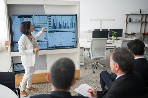 Business consultant presenting a turnaround strategy with charts and graphs in a modern office.