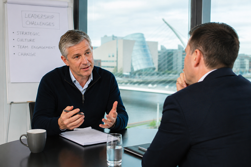 Executive coach discussing leadership challenges with Irish executive