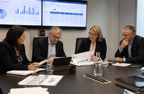 Executive leadership team reviewing governance reports and organisational performance data