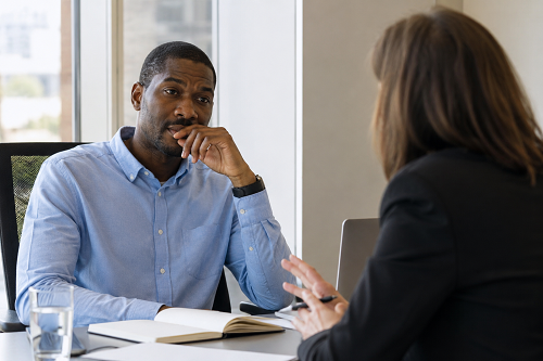 Business leader reflecting during a coaching and development discussion