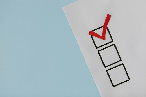 A checklist with one box checked in red and others blank, symbolizing prioritizing tasks during a business health check.