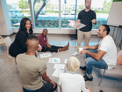 A group of business professionals brainstorming around a table with a growth chart in the background, symbolizing success and innovation.