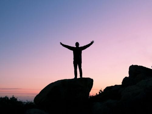 Man standing on mountain.jpg resized Entrepreneur standing on mountain at sunrise symbolising mindset shift and belief reset for business growth