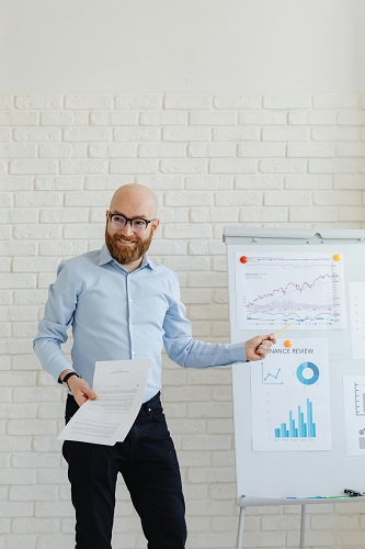 A business professional strategizing on a whiteboard to improve business performance.