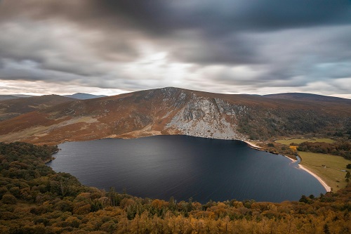 View of Sugarloaf Mountain in County Wicklow, Ireland, with a cloudy sky and lush greenery.