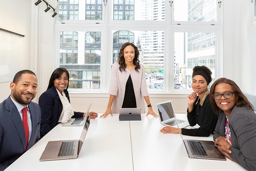 A confident team leader guiding a diverse team during a meeting.