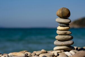 Small pebble stones on top of of each other next to a sea