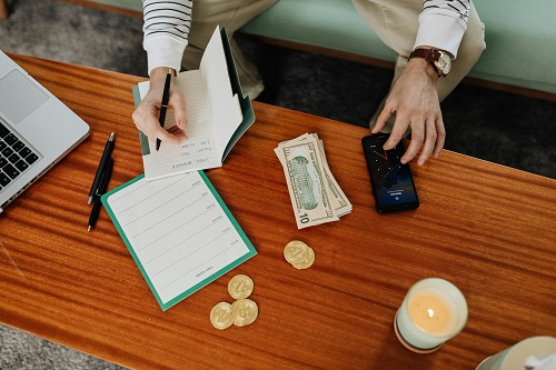 A person reflecting on financial growth with coins and banknotes.