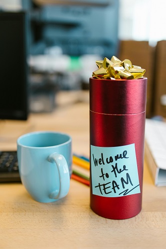 A beautifully wrapped gift with a note that says 'Welcome to the Team' on top.